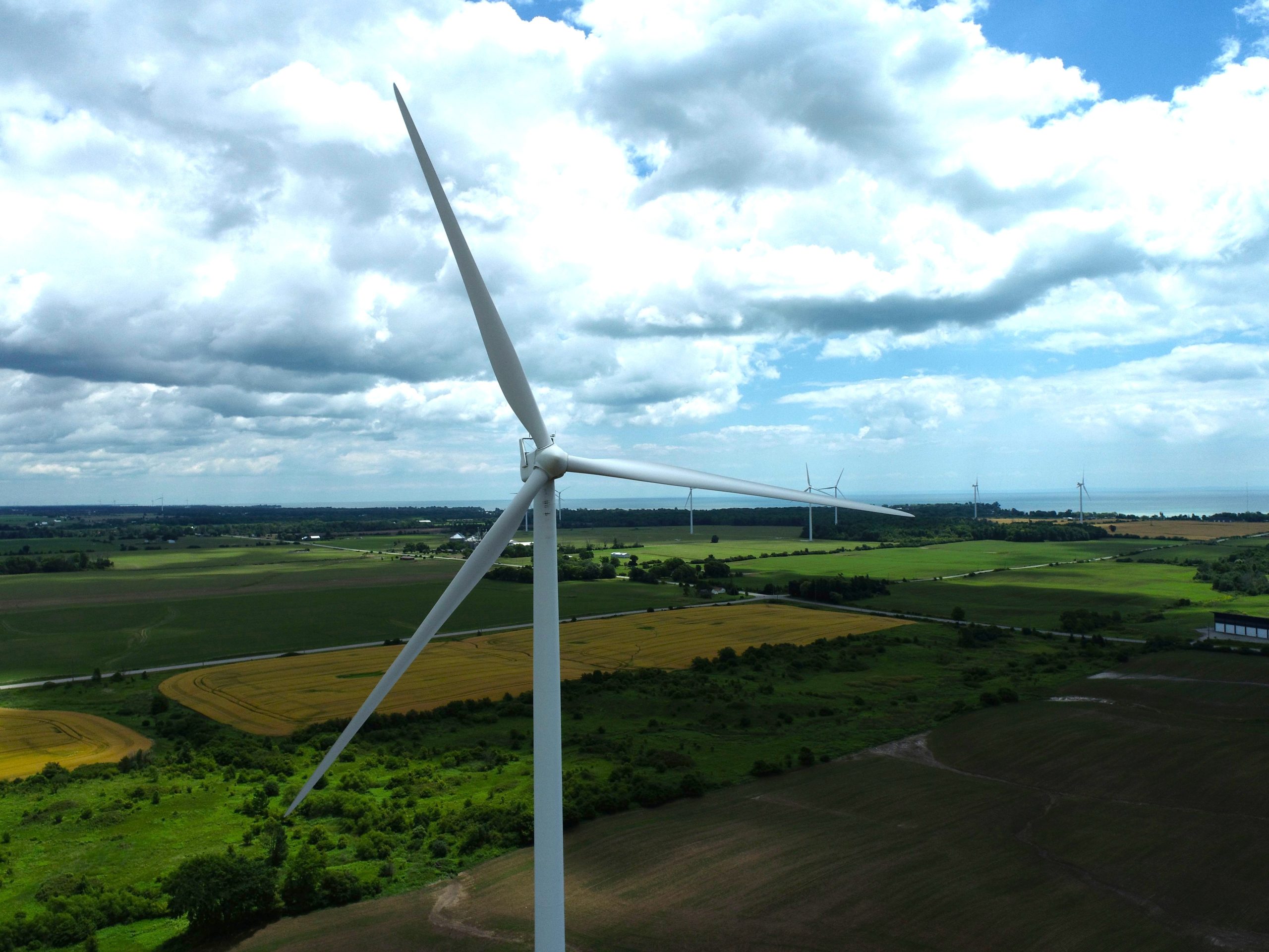 Aerial photo from a UAV of wind turbines with the lake in the distance